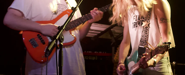 Brooke Dougan and bandmate playing electric guitars.