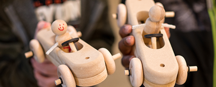 Two children holding hand-made cars.