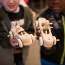 Two children holding hand-made cars.